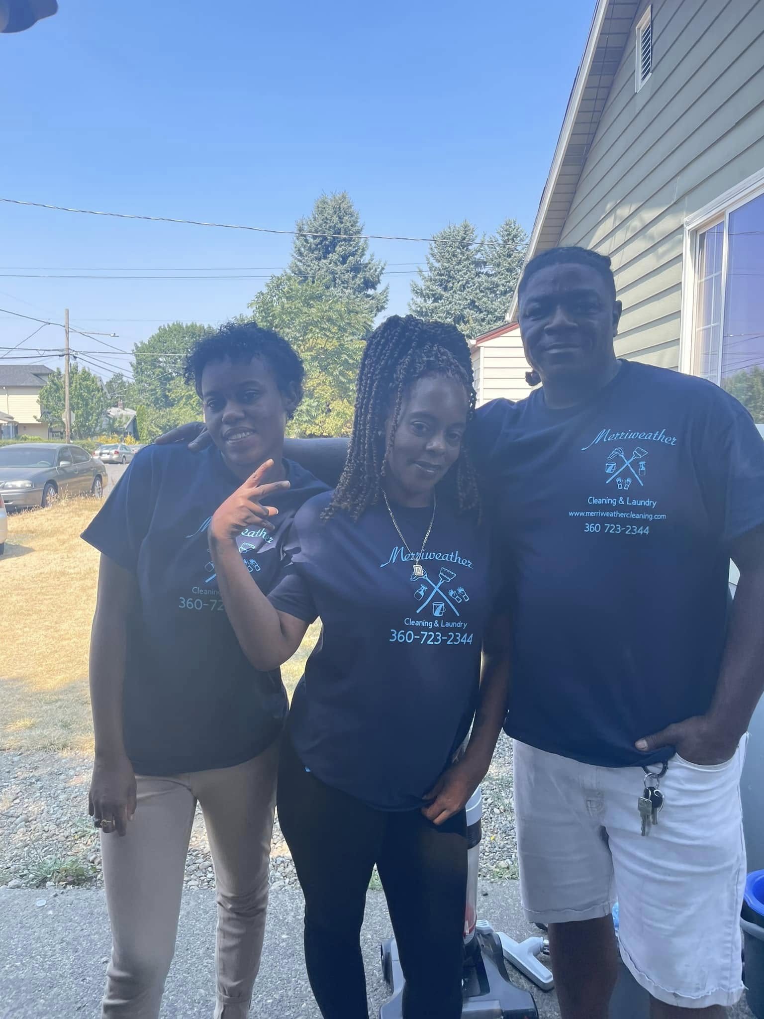 Merriweather Cleaning team of three wearing company shirts in front of a residential home